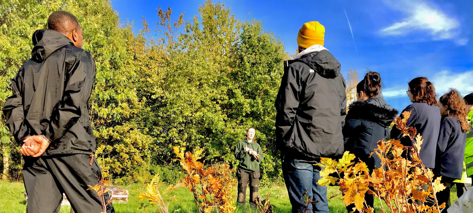 Individuals listening to tree planting demo