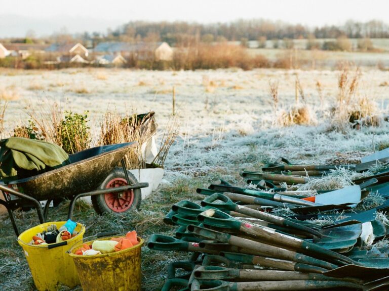 Wheelbarrow, buckets, bundle of spades, and whips.